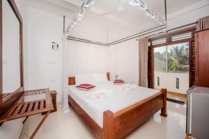 a bedroom with a large bed and a window at Villa Tanzanite Hikkaduwa in Hikkaduwa