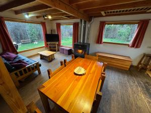 een woonkamer met een houten tafel en een bank bij Casa Mallin Azul in El Bolsón