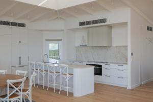 a kitchen with white cabinets and a table and chairs at Oceano House in Copacabana