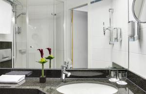 a bathroom with a sink and a shower at Hotel Nürnberg City Center by Leonardo Hotels in Nürnberg +25 photos