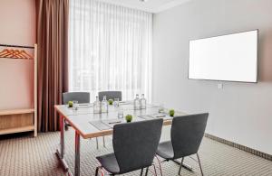 a meeting room with a long table and chairs at Hotel Nürnberg City Center by Leonardo Hotels in Nürnberg