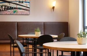 a dining room with two tables and chairs at Hotel Magdeburg City Center by Leonardo Hotels in Magdeburg