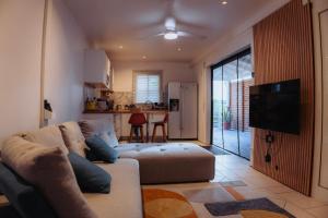 a living room with a couch and a television at la Canne a sucre in Pointe-Noire