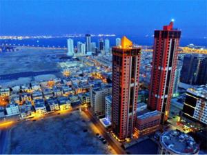 uma vista para o horizonte da cidade à noite em Orange Suites Hotel em Manama