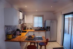 a kitchen with a wooden table and a refrigerator at la Canne a sucre in Pointe-Noire +16 photos