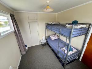 a bedroom with two bunk beds in a room at Mackenzie Cottage in Twizel