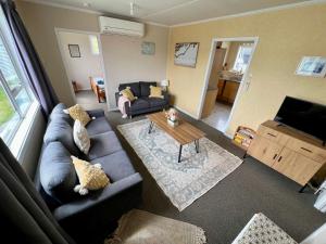 a living room with a couch and a table at Mackenzie Cottage in Twizel