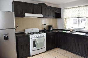 Casa Familiar, Independiente y amplia في Hércules: مطبخ مع موقد ابيض وثلاجة