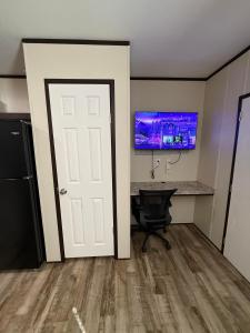 an empty room with a desk and a tv on the wall at Mesquite Oasis Lodging in Odessa