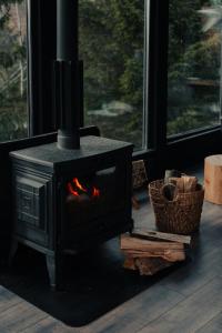 a stove with a fire in a room with a window at Noma Cabin in Măguri +14 photos