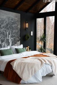 una camera da letto con un letto grande con una grande finestra di Noma Cabin a Măguri