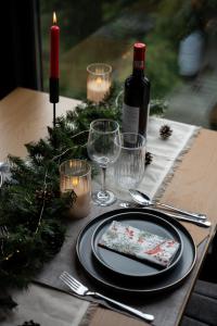 una mesa con un plato con una servilleta y copas de vino en Noma Cabin, en Măguri