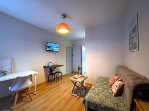 una sala de estar con un sofá y una mesa en Le Repaire des Sablons 2 Pers 150m place du marche, en Fontainebleau