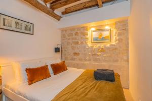 a bedroom with a bed and a stone wall at Exceptional Apartment Île Saint Louis - Jacuzzi in Paris +47 photos