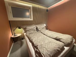 Leilighet في ترومسو: غرفة نوم مع سرير وتلفزيون على الحائط +7 صور