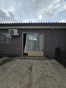 a house with a door with a window and a fan at Recanto do Descanso in São Gabriel