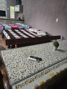 a bed with a remote control on top of it at Recanto do Descanso in São Gabriel