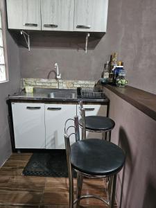 a kitchen with two chairs and a sink at Recanto do Descanso in São Gabriel