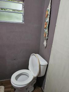 a bathroom with a toilet and a window at Recanto do Descanso in São Gabriel +6 photos