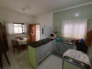 House with Atlantic Forest in the background - Saíra Sete Cores في بيرتيوغا: مطبخ مع حوض وطاولة في الغرفة