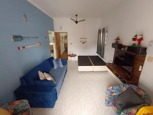 House with Atlantic Forest in the background - Saíra Sete Cores في بيرتيوغا: غرفة معيشة مع أريكة زرقاء وتلفزيون