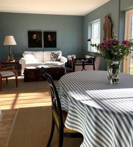 una sala de estar con una mesa y un sofá en Æblehuset Ved Historisk Gods På Sydsjælland, en Præstø