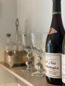 Una botella de vino y dos copas en un estante en Æblehuset Ved Historisk Gods På Sydsjælland, en Præstø