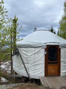 Jurte mit Holztür auf einem Feld in der Unterkunft Yourte La Belle Étoile in Sacré-Coeur-Saguenay
