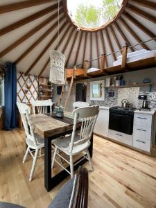 eine Küche mit einem Tisch und Stühlen in einer Jurte in der Unterkunft Yourte La Belle Étoile in Sacré-Coeur-Saguenay