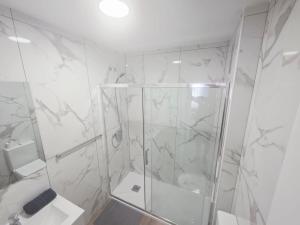 a white bathroom with a shower and a toilet at Spacious 3BR Condo With Pool, Wifi & Near Beach in Callao Salvaje +13 photos