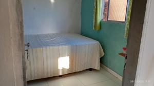 a small bed in a corner of a room at Casa temporada Tucano in Vera Cruz de Itaparica