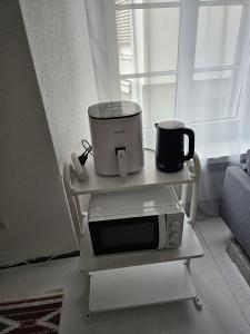 クールにあるPrivate 3-Zimmer Apartment -Private WC, Dusche, Küche-のカートに載った電子レンジとその上に置かれたコーヒーポット