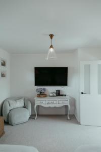 a living room with a tv and a white table at The Pickers Rest in Tasman