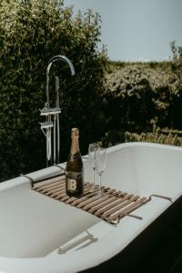 a bottle of champagne and two wine glasses on a bathtub at The Pickers Rest in Tasman +20 photos