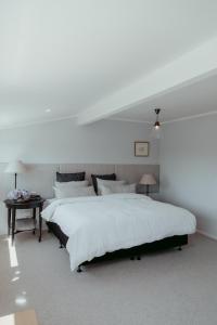 a white bedroom with two beds and a table at The Pickers Rest in Tasman