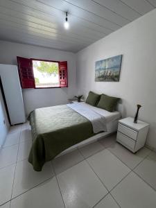 a bedroom with a large bed and a window at Casa Alegria - Praia de Catuama -PE in Goiana