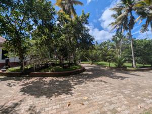 a park with palm trees and a brick road at Marvella dickwella in Dickwella