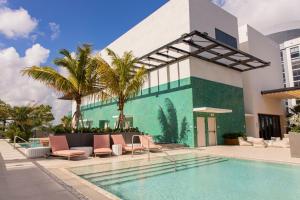 a pool in front of a building with palm trees at The Crosby Miami Worldcenter in Miami