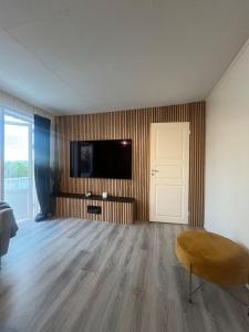 un salon vide avec une télévision et une porte dans l'établissement Large apartment with good view!, à Tromsø