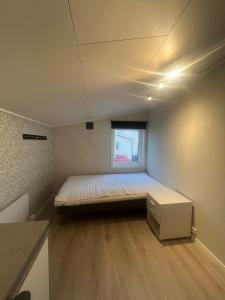 une petite chambre avec un lit et une fenêtre dans l'établissement Large apartment with good view!, à Tromsø