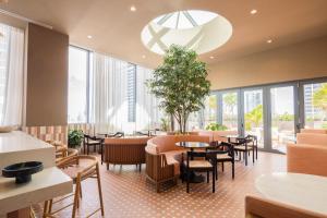 a restaurant with tables and chairs and windows at The Crosby Miami Worldcenter in Miami