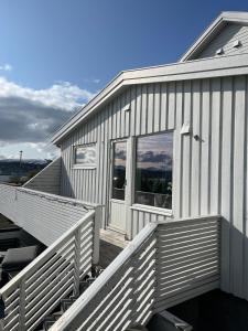 Cette maison blanche dispose d'une grande fenêtre et d'une terrasse couverte. dans l'établissement Large apartment with good view!, à Tromsø 5 autres photos