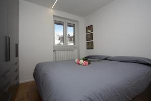 a white bedroom with a bed with flowers on it at Ski Gate - Main Street by Cervino View Experience in Breuil-Cervinia
