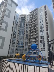 un parque infantil frente a un gran edificio de apartamentos en Mandala - Confort y lujo cerca del parque deportivo, en Ibagué