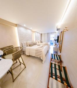 a bedroom with two beds and a table and chairs at Flat Luxo 213 - Pipas Bay in Pipa