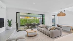 a living room with a couch and a table at Pacific Chill 2 Mins Walk to Beach in Hawks Nest