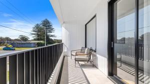 a balcony with two chairs and a view of a street at Pacific Chill 2 Mins Walk to Beach in Hawks Nest