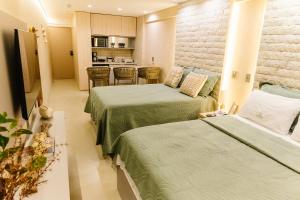 a hotel room with two beds and a kitchen at Flat Luxo 213 - Pipas Bay in Pipa