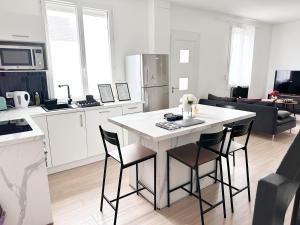 a kitchen with a white table and chairs in a room at Grand Studio WiFi rapide RER B in Sevran