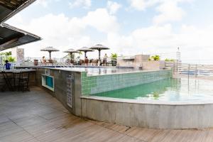 a swimming pool with umbrellas on top of a building at Flat Luxo 213 - Pipas Bay in Pipa +10 photos